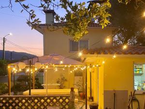 a yellow house with lights in front of it at Casa Palma Hostel in Barcelos