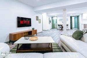 a living room with a white couch and a tv at Spacious Bright Suite - Sleeps 4 - King Bed - NFLX in Edmonton