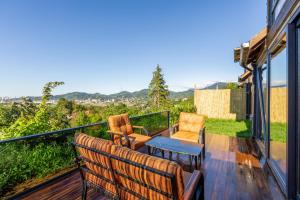 a deck with two chairs and a table on a balcony at Via Bungalows Batumi in Batumi