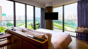 a hotel room with a bed and a large window at YOHO Hollywood Roosevelt Hotel in Macau