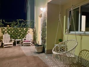 a porch with two chairs and a swing at Casa Palma Hostel in Barcelos