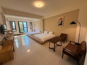 a bedroom with two beds and a table and chairs at 夏米旅宿 in Lukang