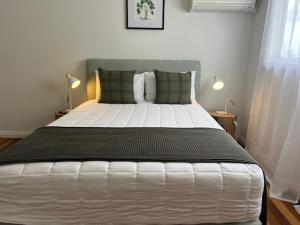 a bedroom with a large white bed with two pillows at The Arabella Motel in Wollongbar