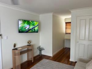 a living room with a tv on the wall at The Arabella Motel in Wollongbar
