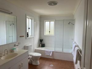 a bathroom with a tub and a toilet and a sink at The Arabella Motel in Wollongbar +1 photo
