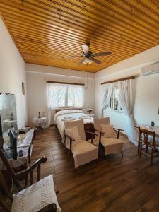 a bedroom with a bed and chairs and a ceiling at Little Paradise in Sotira