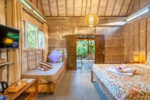 a room with two beds and a tv in it at Ortigia Tropical Lodge in Gili Trawangan +89 photos