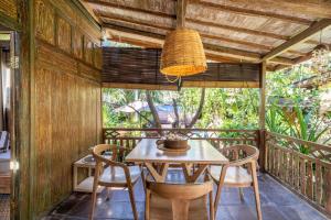 a dining room with a table and chairs on a balcony at Ortigia Tropical Lodge in Gili Trawangan