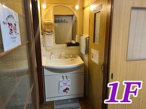a small bathroom with a sink and a mirror at Kyo Yukari in Kyoto +59 photos