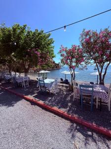 a group of tables and chairs next to the ocean at Mani Sea View Rooms in Gythio