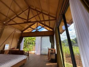 a room with a bed and a large window at Terra Clementia in Watukarung +72 photos