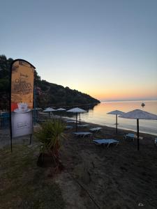 a group of umbrellas and chairs on a beach at Mani Sea View Rooms in Gythio +2 photos