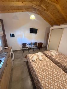 a room with two beds and a table with chairs at Mani Sea View Rooms in Gythio