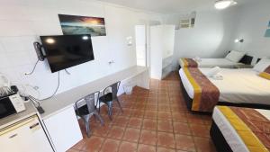 a hotel room with two beds and a television at Sunburst Motel in Gold Coast