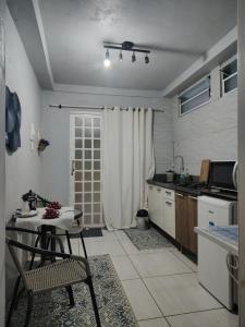 a kitchen with a table and a table and chairs at Casa da Bebel in Uruguaiana