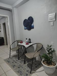 a table with two chairs and a table with balloons on the wall at Casa da Bebel in Uruguaiana +1 photo