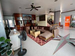 a living room with a couch and a ceiling fan at Metro Residence in Surin
