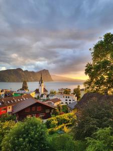 eine kleine Stadt mit einer Kirche und einem Gewässer in der Unterkunft Chalet Oz Vitznau with Lake Lucerne Views in Vitznau