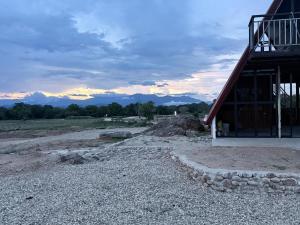 a barn on a field with mountains in the background at Nelli Kale Holiday Resort in Huratgamuwa
