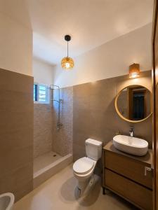 a bathroom with a toilet and a sink and a mirror at My tropical home in La Laguna