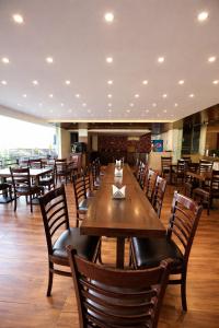 ein Esszimmer mit Holztischen und Stühlen in der Unterkunft The Ginger McLeodGanj-By Vaikunth Centrally Heated & Air Cooled # Near Mall Road # Big Parking # Lift #Spacious Rooms # Most Awarded # Property Of The Year # in McLeod Ganj