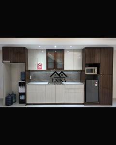 a kitchen with a counter with a microwave and a refrigerator at Unika Coliving Vibes Syariah in Sultan Syarif Kasim II International Airport
