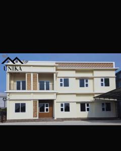 a large white building with a sign on it at Unika Coliving Vibes Syariah in Sultan Syarif Kasim II International Airport