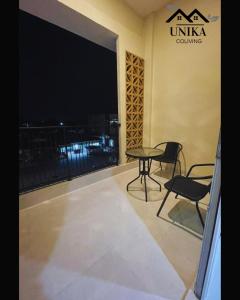 a balcony with a table and chairs in a building at Unika Coliving Vibes Syariah in Sultan Syarif Kasim II International Airport +8 photos