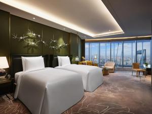 two beds in a hotel room with a view at J Hotel, Shanghai Tower in Shanghai
