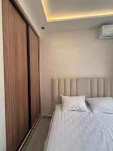 a bedroom with a large bed with a wooden door at اقامة هبة 5 in Yebha