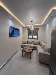 a living room with a couch and a tv at اقامة هبة 5 in Yebha