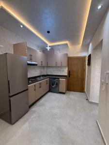a large kitchen with a refrigerator and a dishwasher at اقامة هبة 5 in Yebha