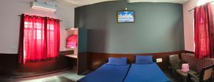 a bedroom with a blue bed and red curtains at Guru kripa hotel and restaurant in Nīmri