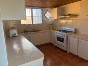 a kitchen with white cabinets and a stove top oven at Casa naranjita in Chame
