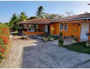 a house with a porch and a driveway at Casa naranjita in Chame