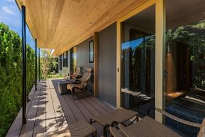 an outdoor deck with chairs and tables on a house at みささ in Kyonan