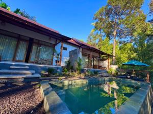 a house with a swimming pool in front of it at AVYANA sanctuary in Gobleg +16 photos