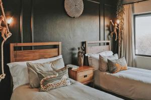 a bedroom with two beds and a clock on the wall at Lala Lodge in Hoedspruit