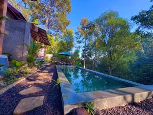 a swimming pool in front of a house at AVYANA sanctuary in Gobleg