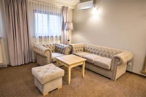 a living room with two couches and a table at Hotel i Restauracja Pod Szyszkami in Krotoszyn