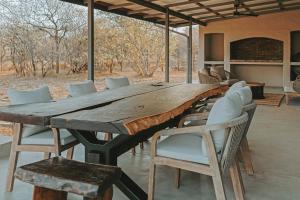 a large wooden table with chairs around it at Lala Lodge in Hoedspruit +22 photos