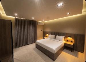 a bedroom with a large white bed in a room at Bluestone Amlak 1 in Medina