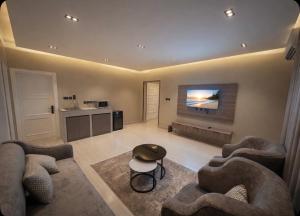 a living room with two couches and a flat screen tv at Bluestone Amlak 1 in Medina