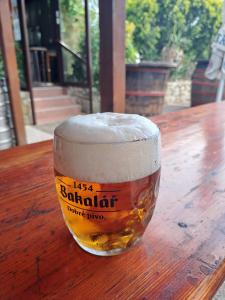 a glass of beer sitting on a wooden table at Ošterija Na Planinci - Škocjan Caves in Divača