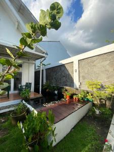 a backyard with a wooden deck with plants on it at Spacious 3BR Villa Near Kaliurang - Arfani's House in Ngaglik