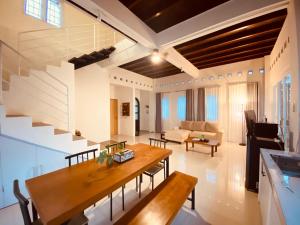 a living room with a wooden table and a couch at Spacious 3BR Villa Near Kaliurang - Arfani's House in Ngaglik