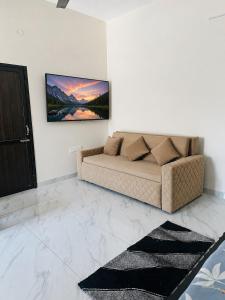 a living room with a couch and a painting on the wall at Forest breeze villa in Jalandhar