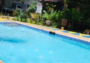 a large swimming pool with blue water and plants at Mannor Beach Resort by Hiverooms in Carmen