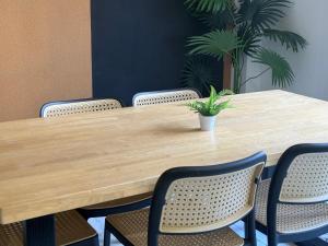 a wooden table with chairs and a potted plant at Apex Hotel by Setapak Central in Kuala Lumpur