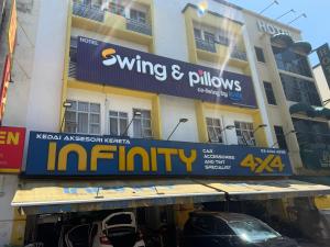 a building with a sign that reads wings and pillows infinity at Apex Hotel by Setapak Central in Kuala Lumpur